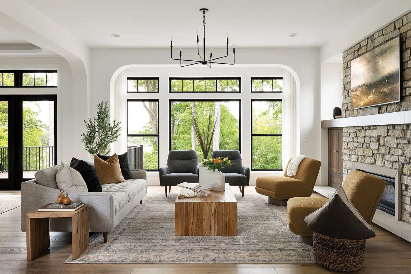 A living room comfortably furnished and awash in natural light from the Andersen® 100 Series Picture and Single-Hung Windows.