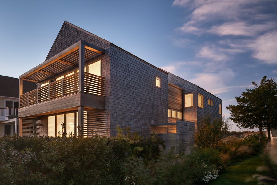 A two-story home with balconies on each level and cedar shingles.