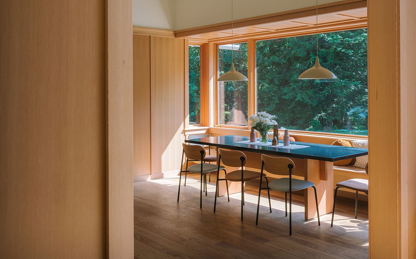 The kitchen features a dining table surrounded on three sides by E-Series Picture and Casement Windows.