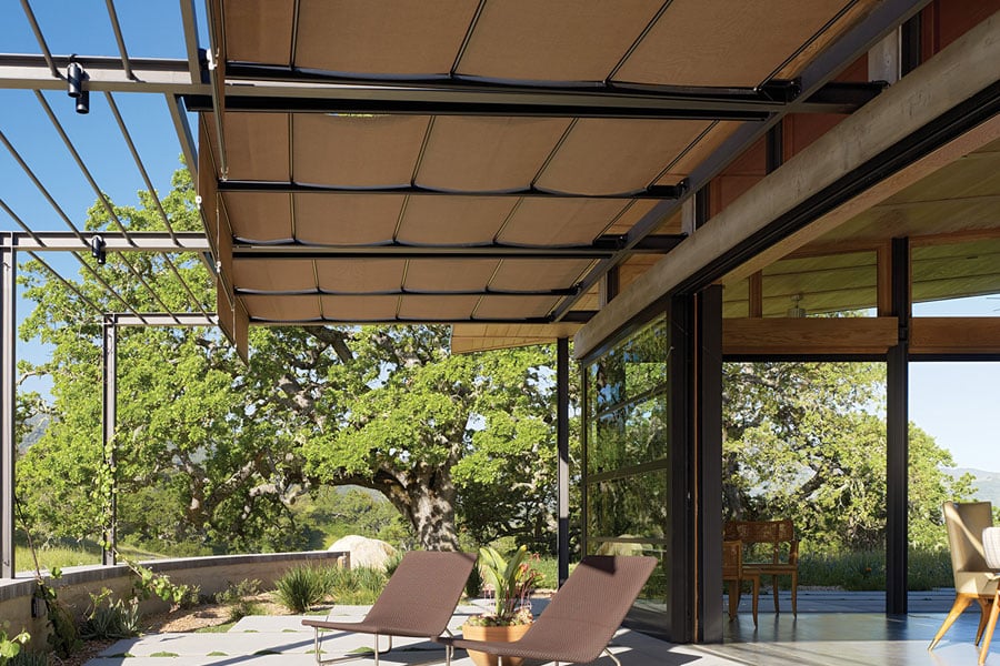 A terrace with overhead beams that accommodate retractable sunshades.