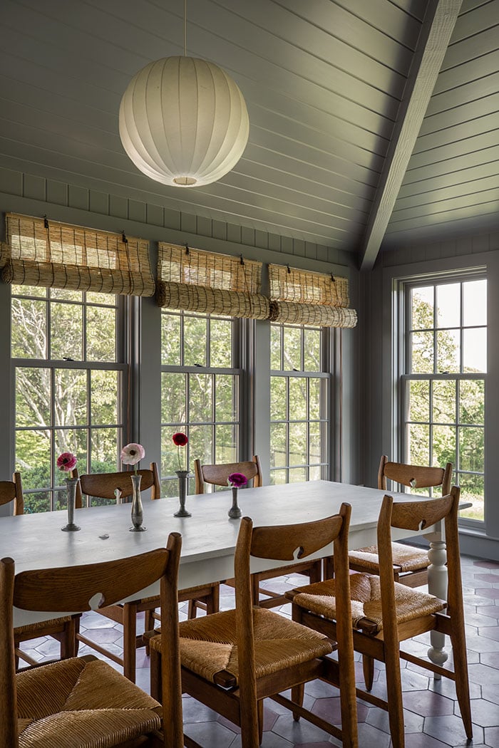 On the left is a sunroom with a wood-paneled cathedral ceiling and a dusty blue monochrome color scheme. On the right is a kitchen with hexagonal floor tiles, an antique wood cabinet and a pet duck.