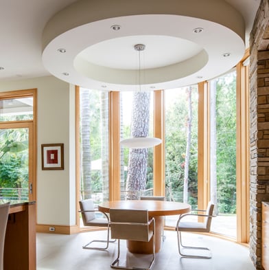 A modern home with a floor-to-ceiling bow window made from Andersen® E-Series Picture Windows.