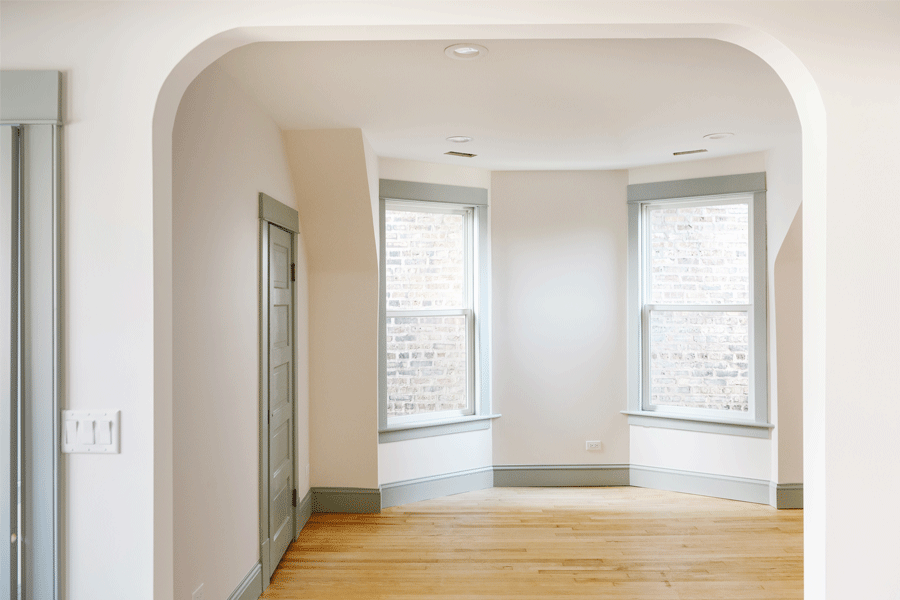 A room with furniture cleared away from windows is ready for window installation day.