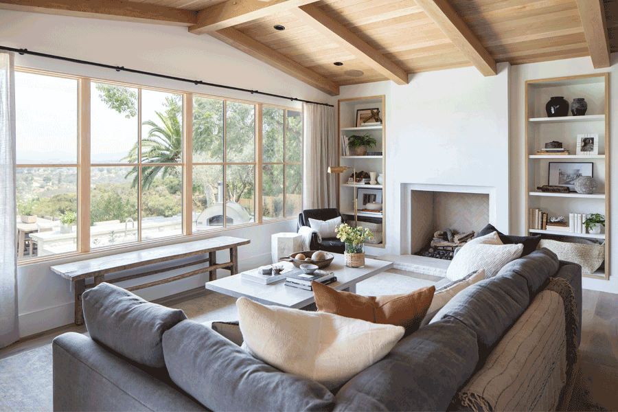 White oak windows in a living room frame a canyon view outside.